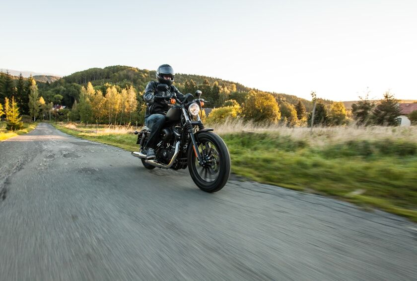 Man riding black motorcycle on country road